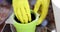 Closeup of gloved hands stirring soil in flowerpot