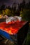 Closeup of glowing ambers in barbecue barrel grilling meat wrapped in aluminium foil during the night