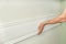 Closeup of gluing wooden white painted plank panel on wall, closeup, carpentry, woodwork, profession, people