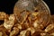 Closeup of Gold Bitcoin Coin and gold nugget on black background.