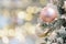 Closeup of golden decorated christmas tree on blurred light background. Branch of christmas tree with balls or baubles. Festive