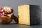 Closeup of gouda cheese and ripe pomegranate on dark table.Fruits and cheeses