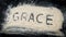 Closeup of GRACE word written on white sand