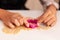 Closeup of grandchild hands making homemade cookie using xmas dough shape