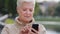 Closeup gray-haired mature woman texting messaging on modern smartphone gadget, scrolling, touching screen, surprised