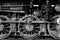 Closeup grayscale shot of an old vintage steam locomotive wheel mechanism details