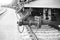 Closeup grayscale of a tank wagons train parts with chains on a blurry background