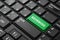 Closeup of a green button with the word revenues,on a black keyboard.Creative background,copy space.Concept magic button