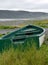 Closeup of a green fishing boat in the grass