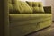 Closeup of green sofa with cushions in the room. Empty couch with velvet covering