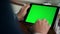 Closeup green tablet screen in luxury office. Man hand swiping mockup device