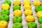 Closeup green and yellow ring eclairs on baking sheet
