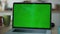 Closeup greenscreen laptop computer on office table. Unknown man working chroma