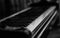 Closeup greyscale shot of a piano on a blurred background