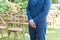 Closeup of a groom in a blue suit waiting for a bride in a garden