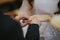 Closeup of the groom putting the wedding ring on his bride\'s finger