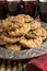 Closeup of a group of assorted flavored cookies. Chocolate chip, macadamia nut, oatmeal raisin, on a silver plate with coffee cups