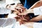 Closeup of a group of businesspeople joining their hands together.