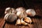 Closeup of a group of Italian garlic cloves on a dark rustic wood table. Light Painting Still Life