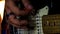 Closeup Guitarist Runs Fingers over Neck Strings in Night Bar