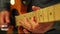 Closeup Guy Runs Fingers Slowly over Guitar Neck in Studio