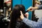 Closeup hairdresser coiffeur makes hairstyle with a comb