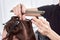 Closeup hairdresser makes hairstyle for young woman in beauty salon