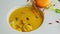 Closeup half-eaten pumpkin cream soup with orange macaron on the bowl