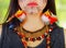 Closeup half face of beautiful amazonian exotic woman with facial paint and black dress, posing seriously for camera