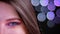 Closeup half face shoot of young attractive caucasian female with pink beautiful pink glitter makeup with dark brown