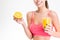 Closeup of half orange and juice holded by fitness woman