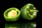 Closeup halved green bell peppers isolated on black