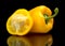 Closeup halved yellow bell peppers isolated on black