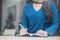 Closeup hand asian woman sitting study and learning writing notebook and diary on table in at cafe shop