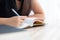 Closeup hand asian woman sitting study and learning writing notebook and diary on table in living room at home