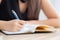 Closeup hand asian woman sitting study and learning writing notebook and diary on table in living room at home, girl homework