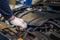 Closeup hand of auto mechanic examine car engine breakdown problem in front of automotive vehicle car hood. Safety technical
