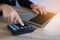 Closeup hand of business woman working with calculator and laptop for analyze report at office