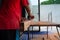 Closeup hand of carpenter holds electrical tool scrubbing the surface of wood