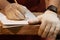 Closeup hand of Carpenter using pencil sketching design woodwork furniture with paper drawing in carpentry workshop