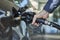 Closeup of a hand filling a fuel tank of a car with fuel dispenser in petrol station