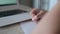 Closeup of a hand with a fountain pen. A child writes in a notebook doing homework while sitting at a desk. Left camera