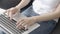 Closeup hand of freelance woman working and typing on laptop computer sitting on couch at living room