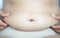 Closeup hand holding abdominal surface woman fat, healthy care and beauty concept