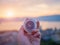 Closeup hand holding compass with mountain and sunset sky