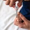 Closeup of a hand holding little scissors to cut nails on tiny babyâ€™s foot