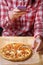 Closeup hand holding phone shooting food photograph a table in a restaurant in a red plaid shirt. copy space for design