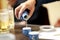 Closeup Hand of man pouring Japanese Sake into sipping ceramic bowl on the wooden table background. Japanese drink style. Warm