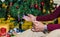 Closeup hand of senior man on knee with decorating Christmas tree background. lonely holiday concept. celebrating Christmas and