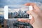 Closeup of a hand with smartphone taking a picture of Kuala Lumpur skyline Malaysia